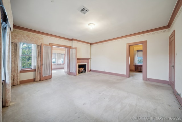 1340 E 9th St, Okmulgee, OK 74447 - unfurnished living room featuring crown molding, radiator, a lit fireplace, baseboards, and light carpet