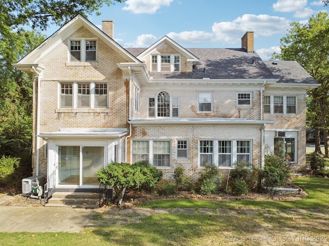 view of front of house with brick siding, entry steps, and a chimney