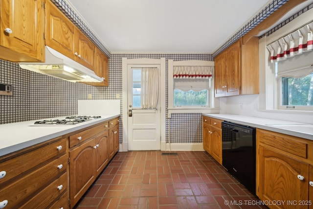 kitchen featuring under cabinet range hood, white gas cooktop, dishwasher, and light countertops