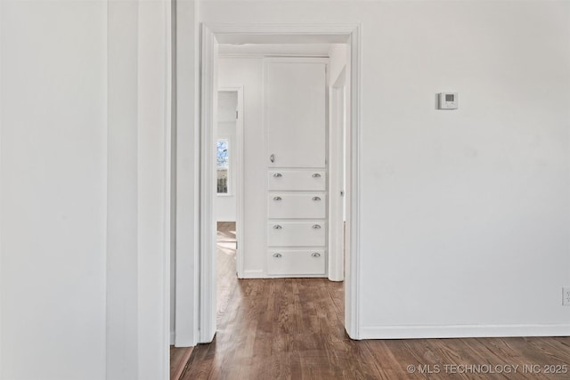 hallway with baseboards and dark wood-style flooring