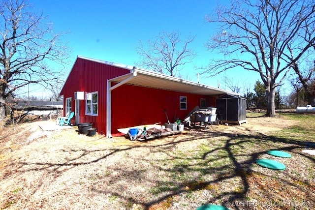 view of side of property featuring an outdoor structure and a sunroom