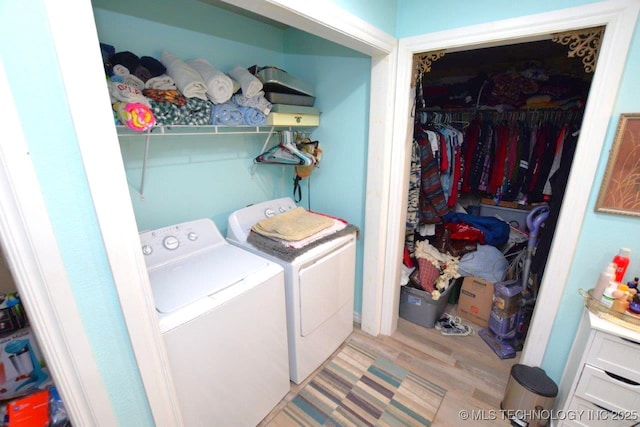 washroom featuring wood finished floors, washing machine and dryer, and laundry area