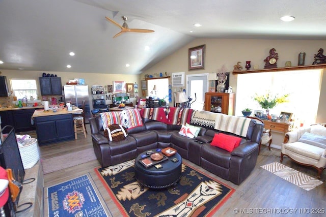 living room with recessed lighting, light wood-style flooring, a ceiling fan, and lofted ceiling