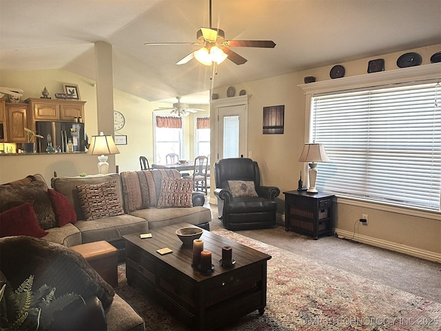 living room with baseboards, lofted ceiling, light carpet, and a ceiling fan