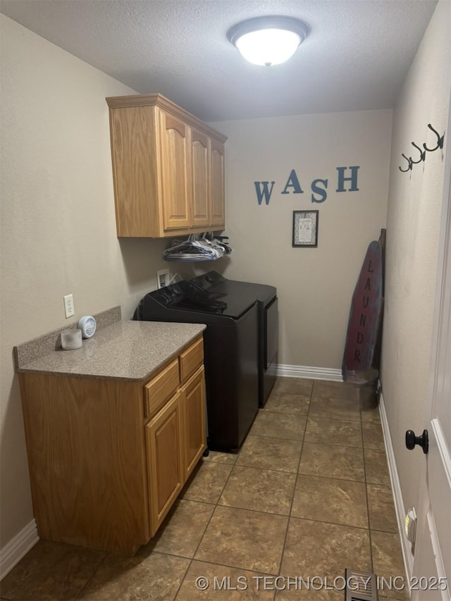 washroom with tile patterned flooring, cabinet space, a textured ceiling, and baseboards