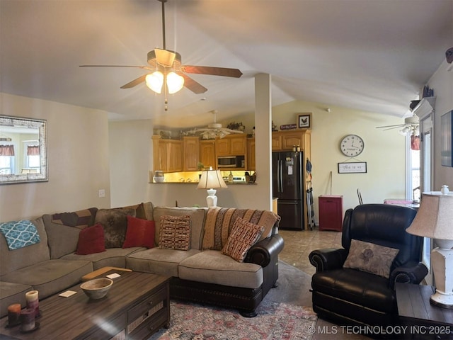 living area featuring a ceiling fan, lofted ceiling, light tile patterned flooring, and a healthy amount of sunlight