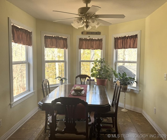 dining space with baseboards, plenty of natural light, and dark tile patterned flooring