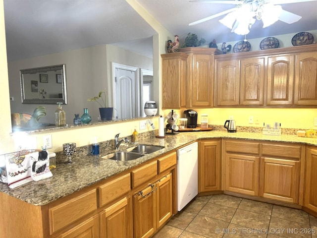 kitchen featuring a sink, light tile patterned flooring, stone counters, dishwasher, and ceiling fan