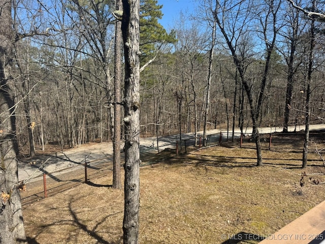 view of yard featuring fence and a wooded view