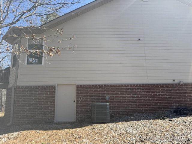 view of home's exterior featuring cooling unit and brick siding