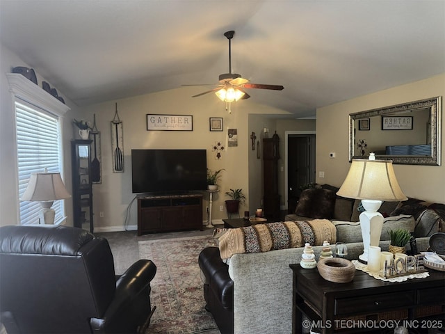 living area featuring baseboards, a ceiling fan, carpet flooring, and vaulted ceiling