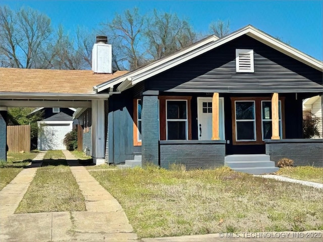 bungalow-style house with covered porch, a chimney, and roof with shingles