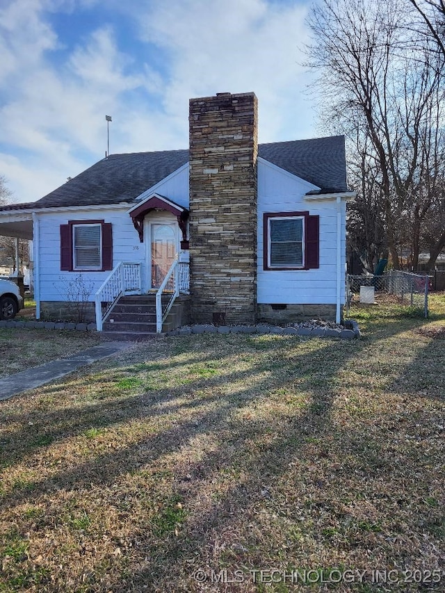 bungalow-style home with a shingled roof, a chimney, a front lawn, a carport, and crawl space