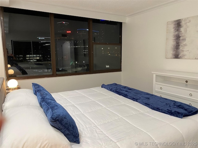 bedroom featuring a textured ceiling and ornamental molding