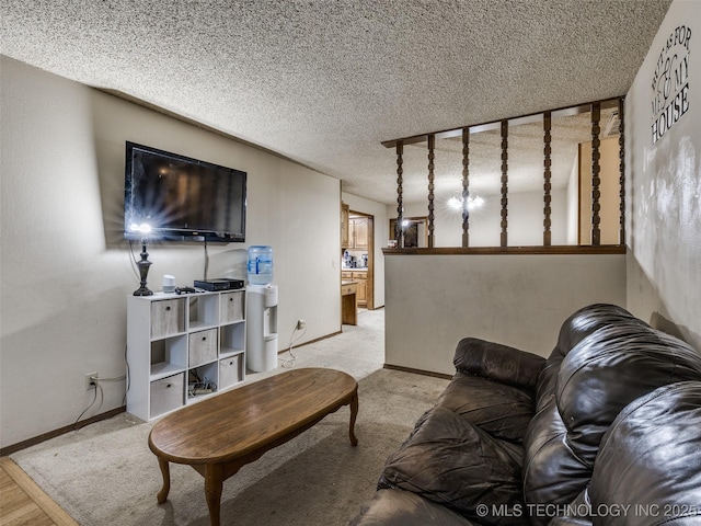 living area with light colored carpet, baseboards, and a textured ceiling