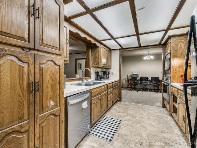 kitchen featuring a sink, light countertops, brown cabinetry, and stainless steel appliances