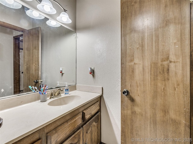 bathroom featuring vanity and a textured wall