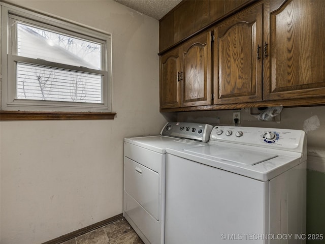 washroom with washing machine and clothes dryer, cabinet space, and baseboards