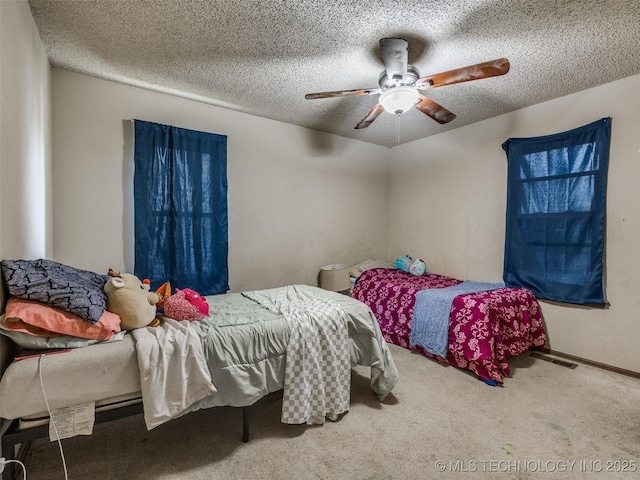 bedroom with visible vents, a ceiling fan, a textured ceiling, carpet floors, and baseboards