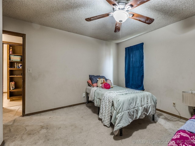 bedroom with carpet flooring, a ceiling fan, baseboards, and a textured ceiling