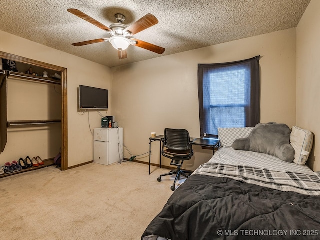 bedroom with a ceiling fan, baseboards, carpet, a closet, and a textured ceiling