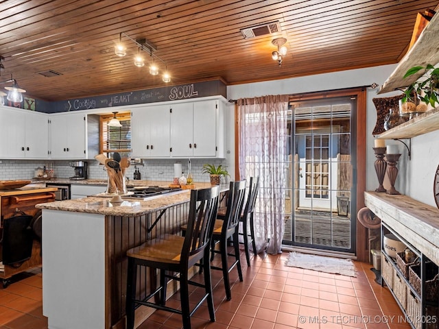 kitchen featuring wooden ceiling, tasteful backsplash, and visible vents