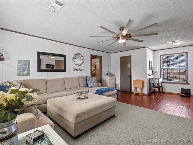 tiled living room featuring visible vents, a textured ceiling, carpet, crown molding, and ceiling fan