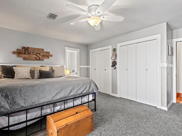 bedroom featuring a ceiling fan, carpet flooring, visible vents, and multiple closets