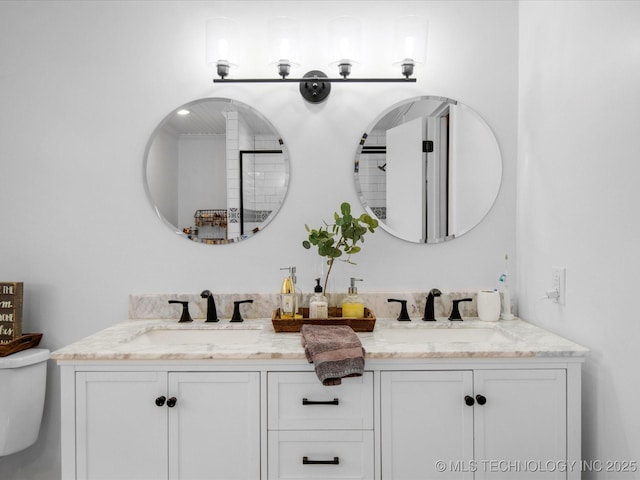 full bath with a sink, toilet, and double vanity