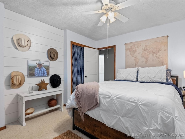 carpeted bedroom featuring ceiling fan, a closet, and a textured ceiling