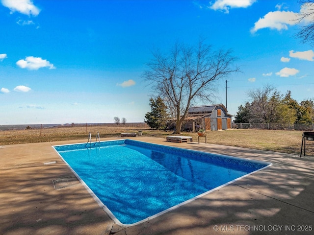 view of swimming pool featuring a patio, fence, a fenced in pool, an outdoor structure, and a lawn