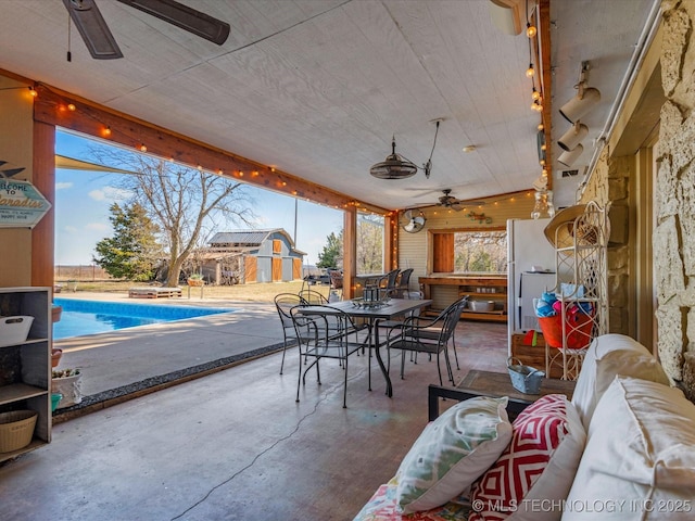 sunroom / solarium featuring a ceiling fan