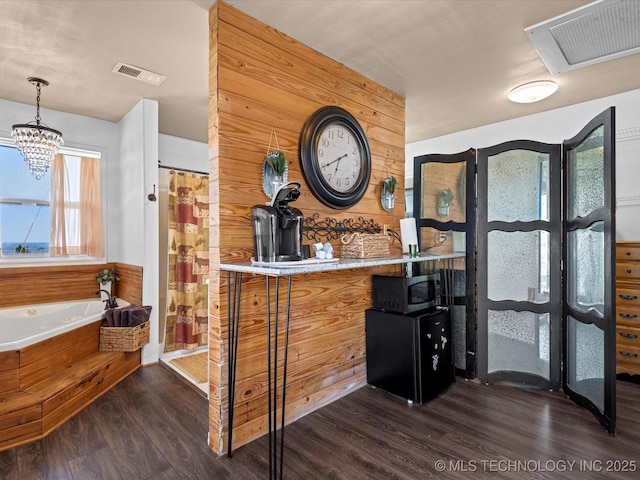 bar with visible vents, stainless steel microwave, and wood finished floors