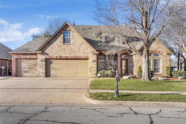 french country home with a front lawn, stone siding, roof with shingles, concrete driveway, and a garage