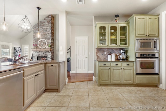 kitchen with light tile patterned floors, visible vents, a fireplace, stainless steel appliances, and backsplash