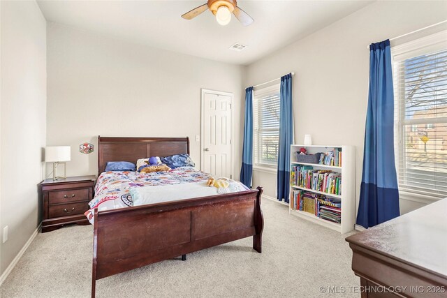 carpeted bedroom with visible vents, baseboards, and a ceiling fan