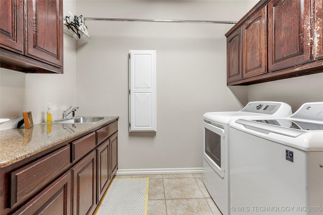 laundry area with washer and dryer, a sink, cabinet space, light tile patterned floors, and baseboards