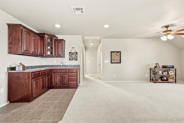 kitchen with visible vents, light colored carpet, glass insert cabinets, and a ceiling fan