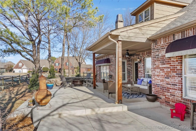 view of patio with an outdoor living space with a fire pit and fence