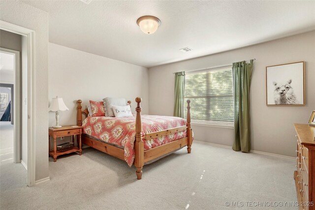 bedroom with visible vents, light colored carpet, and baseboards