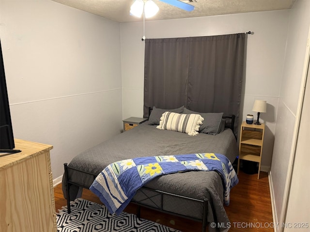 bedroom with a textured ceiling and wood finished floors