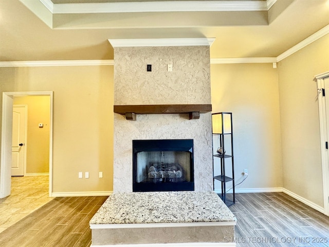 living room featuring baseboards, ornamental molding, and wood tiled floor