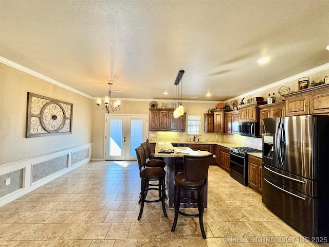 kitchen with a kitchen island, a sink, stainless steel appliances, crown molding, and a kitchen breakfast bar