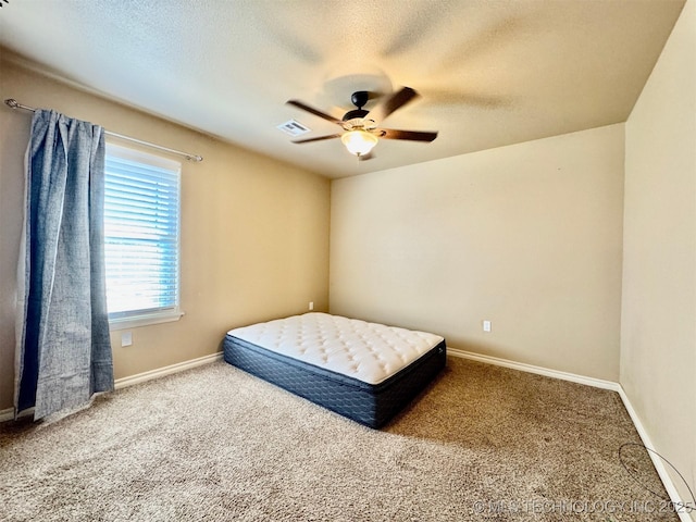 carpeted bedroom with baseboards, a textured ceiling, and ceiling fan