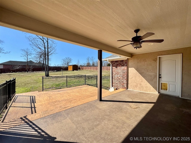 view of patio with a storage shed, an outdoor structure, a ceiling fan, and fence