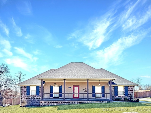 view of front facade with a front lawn, a porch, fence, and stucco siding