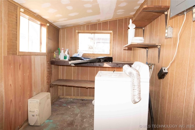 laundry room with a wealth of natural light, laundry area, wood walls, and washer / dryer