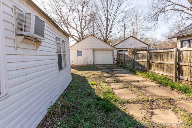 view of yard with a detached garage, an outdoor structure, and fence