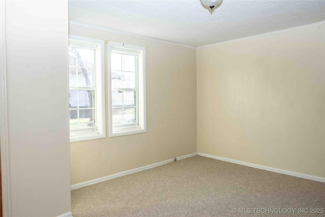 spare room featuring carpet, baseboards, and ornamental molding