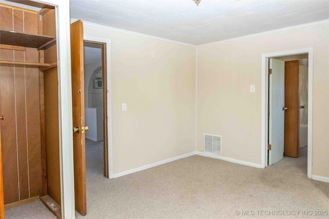 unfurnished bedroom featuring visible vents, carpet, and crown molding